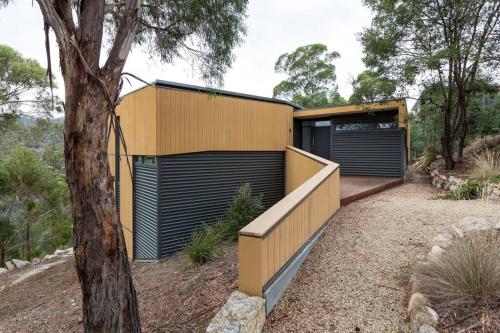 a house with two garage doors and a tree at Luxurious, Tranquil and Private in Lindisfarne