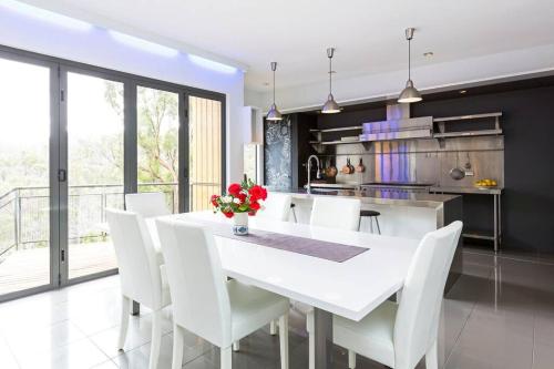 a white dining room with a white table and white chairs at Luxurious, Tranquil and Private in Lindisfarne