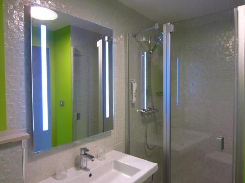 a bathroom with a sink and a shower and a mirror at ibis Styles Saint Malo Port in Saint Malo