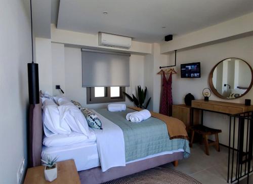 a bedroom with a bed and a mirror at PANORMUS Luxury House in Panormos Rethymno