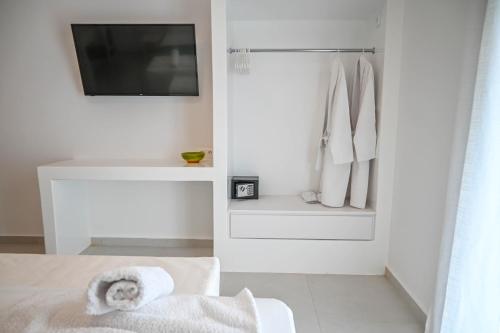 a white room with a tv and a towel at Levanta guesthouse in Schinoussa