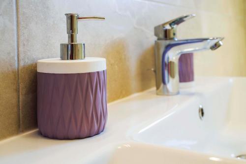 a purple and white toothbrush holder sitting on a sink at Ve & Ki in Podstrana