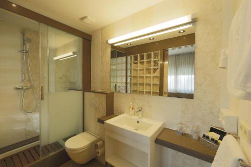 a bathroom with a sink and a toilet and a mirror at Lux Isla in Talamanca