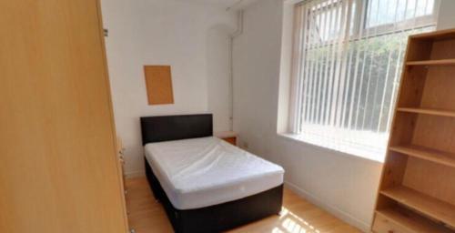 um pequeno quarto com uma cama e uma janela em Cosy House Relaxing Rooms close to all amenities 