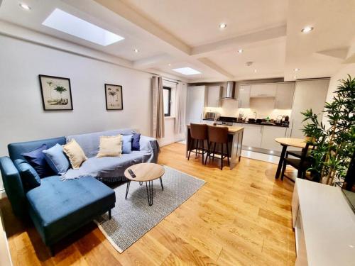 Il comprend un salon avec un canapé bleu et une cuisine. dans l'établissement Luxurious Apartment in Nottingham Lace Market, à Nottingham
