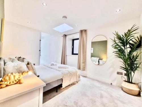 een witte slaapkamer met een bed en een spiegel bij Luxurious Apartment in Nottingham Lace Market in Nottingham
