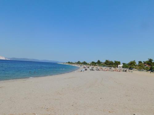 a beach with a lot of people in the water at Κωνσταντίνος Έλενα Studios in Pefki