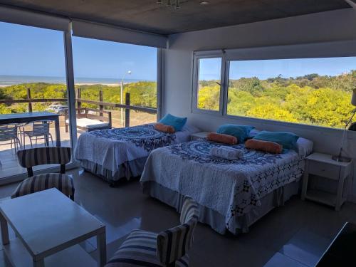 - 2 lits dans une chambre avec une grande fenêtre dans l'établissement Linda Bay 202, à Mar de las Pampas