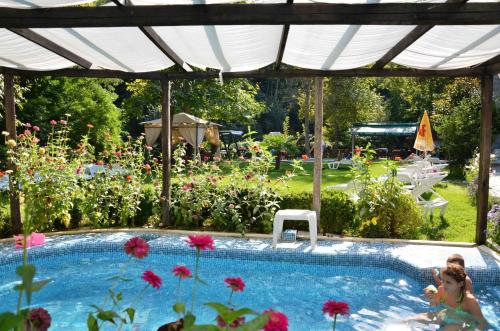 a girls playing in a swimming pool in a garden at Family Hotel BOHEMA in Ognyanovo