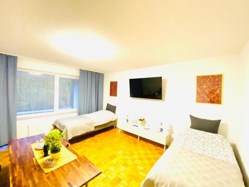 漢諾威的住宿－Welcome to Messe!-Two-Bedroom Apartment&Balcony，酒店客房设有两张床和一张桌子。