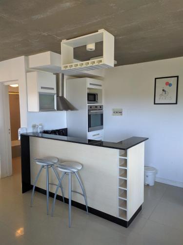 a kitchen with a counter and two stools at Linda Bay 202 in Mar de las Pampas