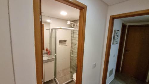 Un baño con ducha, inodoro y espejo. en Néctar de Enseada apart a 50mt da praia Cabo de Santo Agostinho, en Cabo de Santo Agostinho