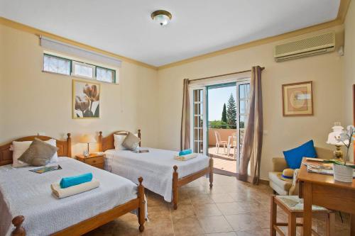 een slaapkamer met twee bedden en een balkon bij Villa Boavista by Villa Plus in Boliqueime