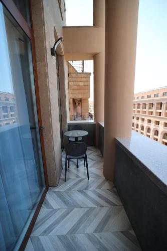 a balcony with a table and a chair in a building at AVENUE RESIDENCE by AY North Avenue in Yerevan