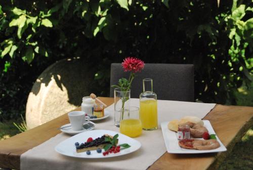 a table with two plates of food and a glass of orange juice at Nebbiolo Wine B&B in Castione Andevenno