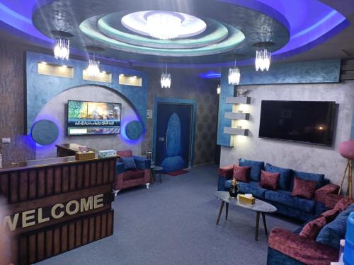 a lobby with a waiting room with couches and a television at Shihan hotel suites in Amman