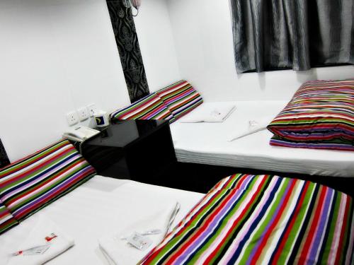 two beds in a room with colorful striped sheets at Australia Lounge in Hong Kong