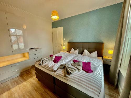 a bedroom with a large bed with purple pillows at Altstadtdomizil Wohnung Hygge in Borkum