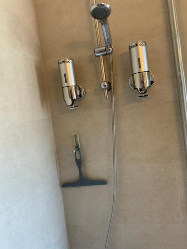prysznic z trzema srebrnymi kubkami na ścianie w obiekcie Cannes Marina Résidence Le Surcouf - Studio de 28m2 au 10ème étage avec piscine, terrasse, parking, vue montagne et port : Mandelieu-La Napoule w mieście Mandelieu-la-Napoule