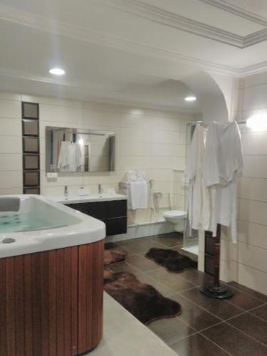 a bathroom with a tub and a sink and a toilet at Hotel Raya Tichy in Tichi