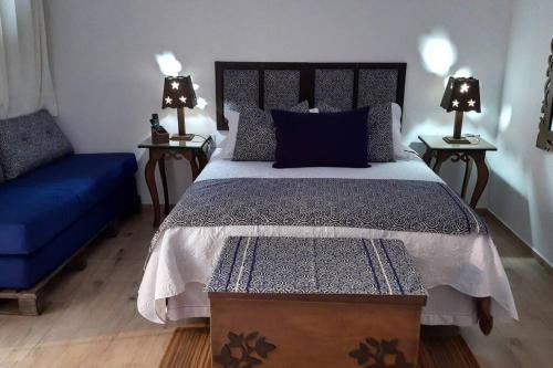 1 dormitorio con 1 cama y 1 sofá azul en Studio no Centro de São Joaquim/SC, en São Joaquim