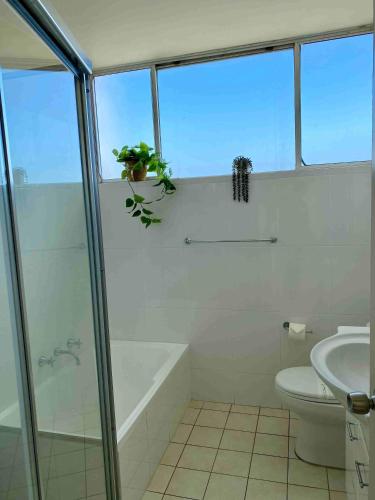 a bathroom with a tub and a toilet and a sink at Ebbtide 29 - All linen supplied Bunk linen provided for self-making in Forster