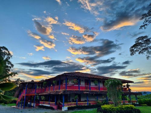 a building under a cloudy sky at sunset at El Percal Hacienda Hotel in Montenegro