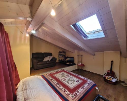 sypialnia z łóżkiem, kanapą i oknem dachowym w obiekcie Casa Vacanze PRINCIPE LORIS w mieście Canale