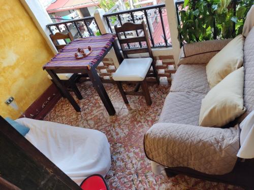 a balcony with a couch and a table and chairs at CASA EL CALVARIO in Antigua Guatemala