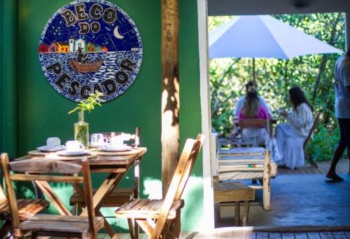 a table and chairs with a plate on the wall at Beco do Pescador in Caraíva