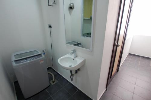 y baño con lavabo y espejo. en Imperial Suites Miri , Diamond Tower, en Miri