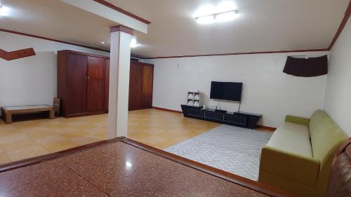 a living room with a couch and a tv at The Red House in Sokcho