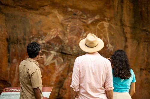 a group of three people looking at a painting at Cooinda Lodge Kakadu in Jabiru