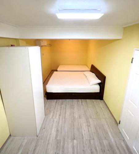 a small bedroom with a bed in a room at Daora guesthouse in Garapan