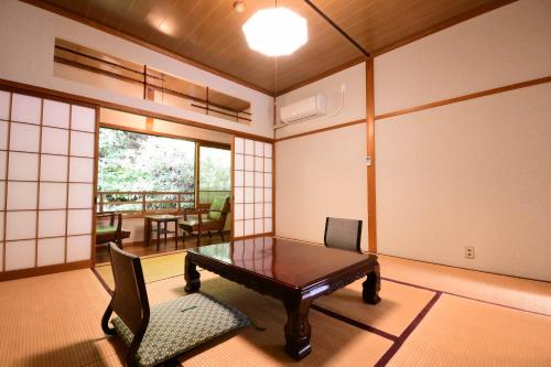 a room with a table and chairs in a room with a view at 高野山 宿坊 宝城院 -Koyasan Shukubo Hojoin- in Koyasan