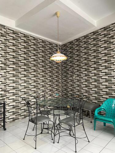 a dining room with a glass table and chairs at Villa Bukit Indah in Berastagi