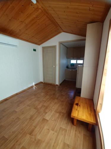a living room with a wooden table and a kitchen at The Red House in Sokcho
