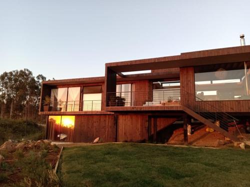 a large wooden house with a large deck at Hermosa y acogedora parcela cerca de viñas y playa in Algarrobo