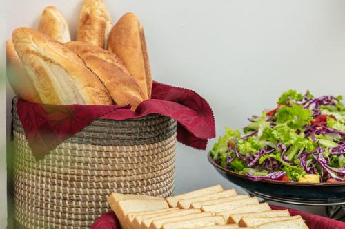 a basket of bread and a salad with a bowl of lettuce at New Airport Hotel in Noi Bai