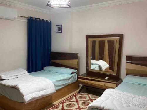 a bedroom with two beds and a mirror at Unique Seaview 3-Bedroom Apartment in Alexandria