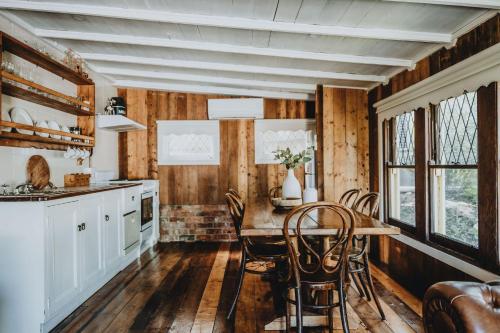 a kitchen with wooden walls and a table and chairs at The Dairy in Castlemaine