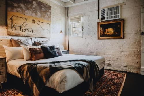 a bedroom with a bed and a brick wall at The Dairy in Castlemaine