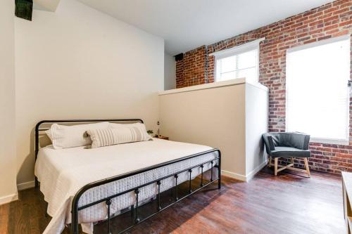 a bedroom with a bed and a brick wall at Cozy Chic Retreat in the Heart of RVA in Richmond