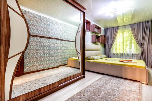 a bedroom with a mirror and a bed in it at 417. Отличный вариант для туристов и командированных. Самый центр. Арбат in Almaty