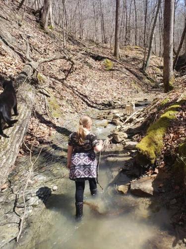 a woman standing in a stream in the woods at Red River Gorge Creekside, New*Spacious *2 baths! in Stanton
