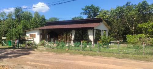 um pequeno edifício ao lado de uma estrada de terra em Done Right em Phumĭ Chroŭy Svay