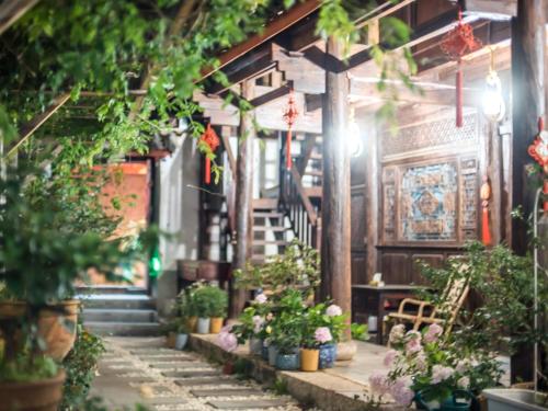 a hallway with potted plants and stairs in a building at Tuo Tuo Guest House in Lijiang