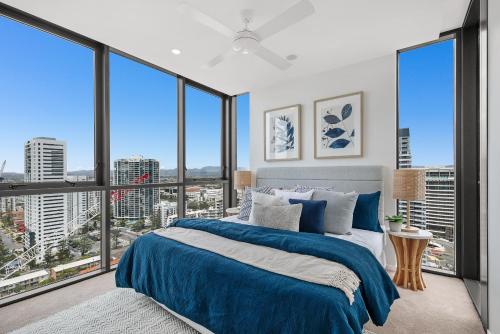 a bedroom with a bed and large windows at Koko Broadbeach in Gold Coast