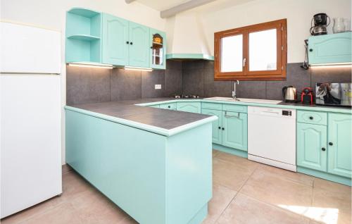 La cuisine est équipée de placards bleus et d'un réfrigérateur blanc. dans l'établissement Amazing Home In Les-Salles-Du-Gardon, à Les Salles-du-Gardon
