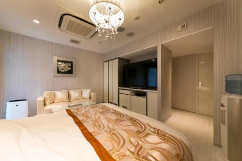 a bedroom with a large bed and a flat screen tv at HOTEL ELDIA (Adult Only) in Gyōda